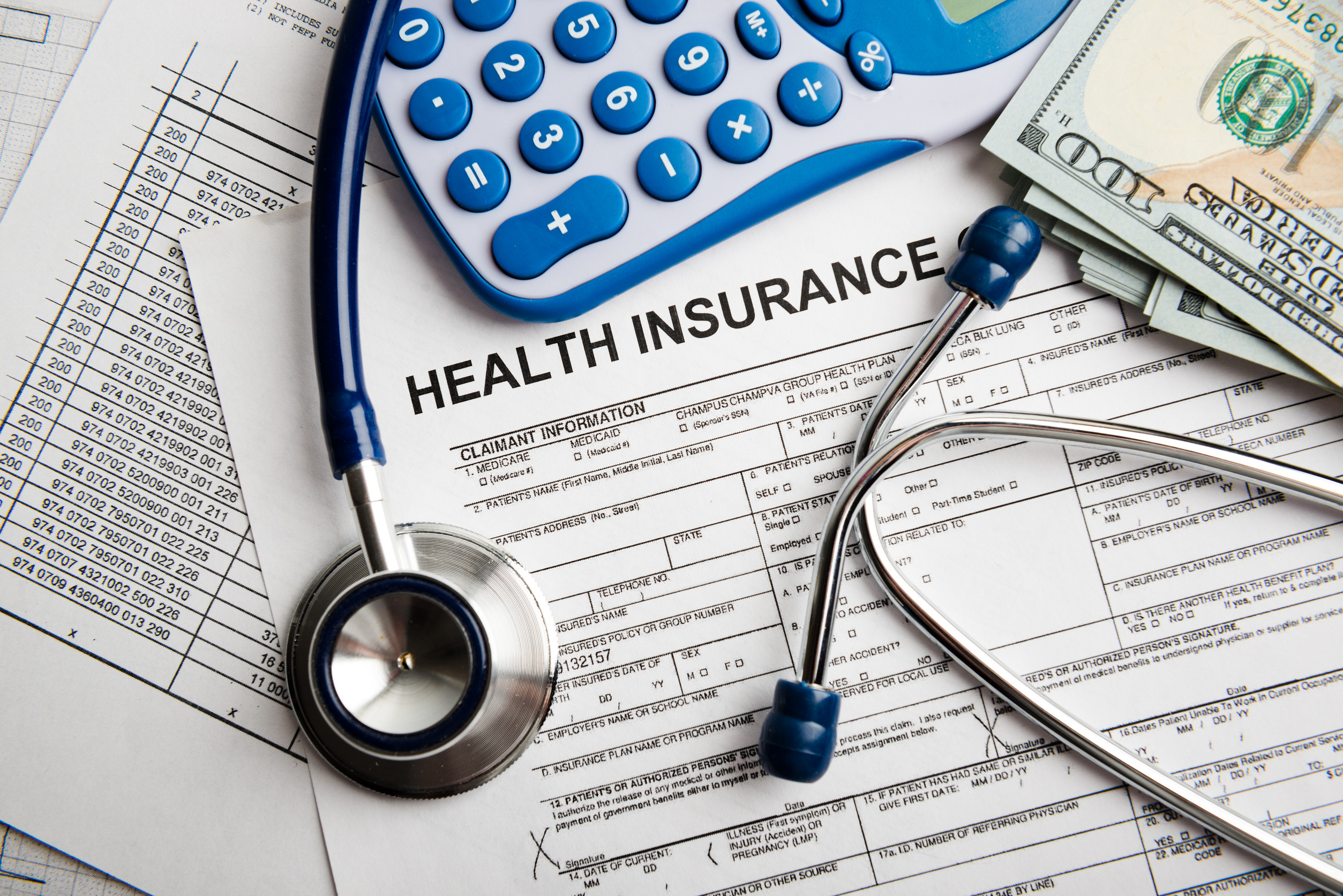 Health insurance application form with banknote and stethoscope